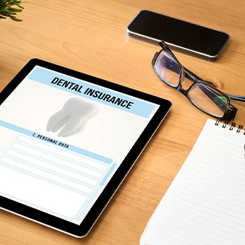 Dental insurance form on tablet on desk with notepad