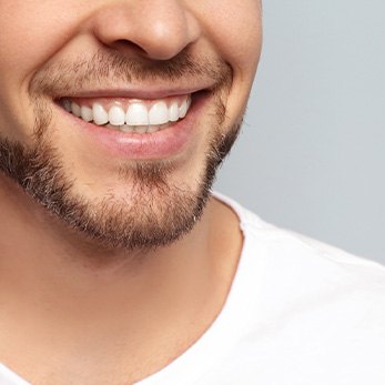 Nose-to-shoulder view of man smiling with nice teeth