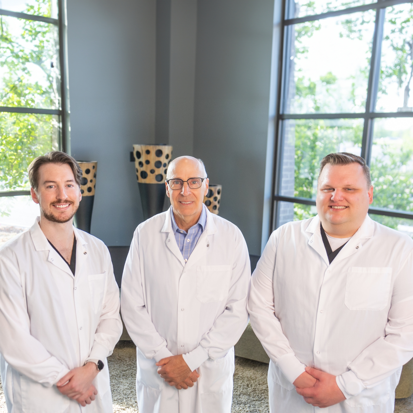 Dr Erickson Mercer and Reed standing and smiling