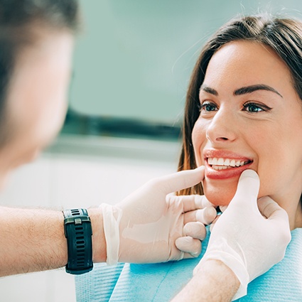 Woman smiling as dentist inspects her teeth