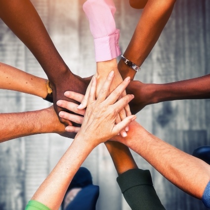 People in a circle putting their hands together