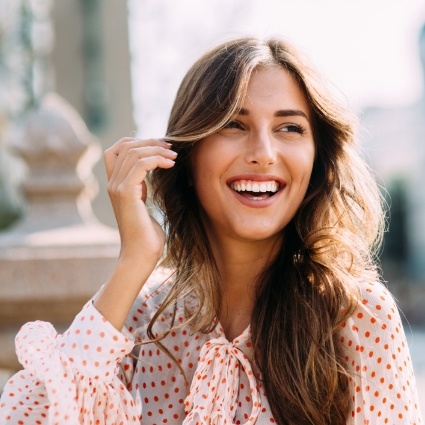 Woman wearing polka dotted shirt and smiling