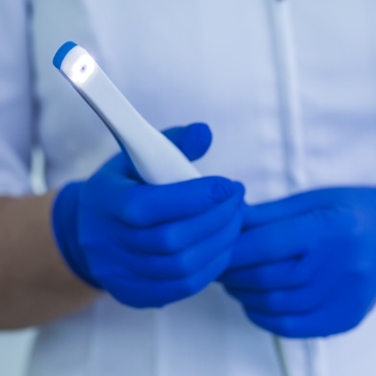 Gloved hands holding intraoral camera