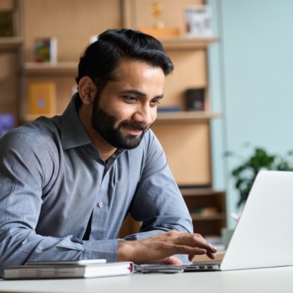 Smiling man working on a laptop