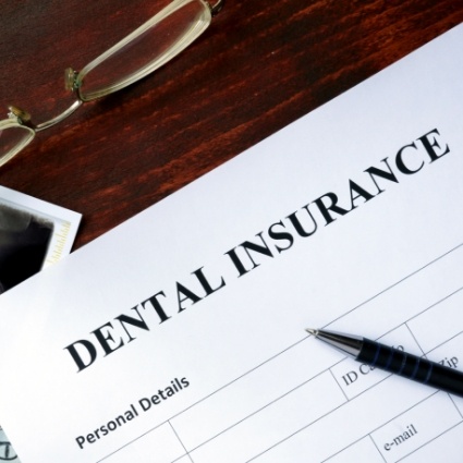 Dental insurance form with glasses and pen