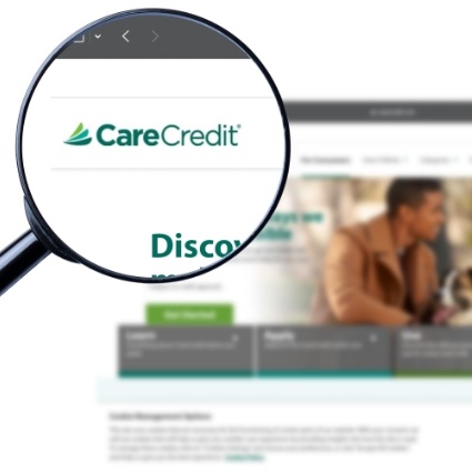 Magnifying glass showing CareCredit logo on website