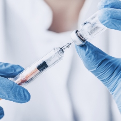 Dentist holding needle and small bottle