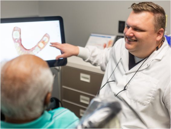 Dentist showing patient scan of teeth