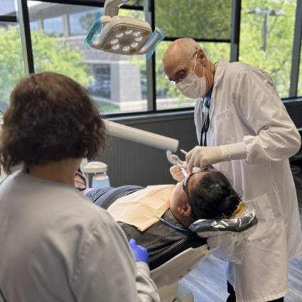 Dentist and team member with dental patient in chair