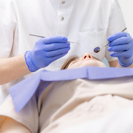 Patient lying down with dentist standing over them