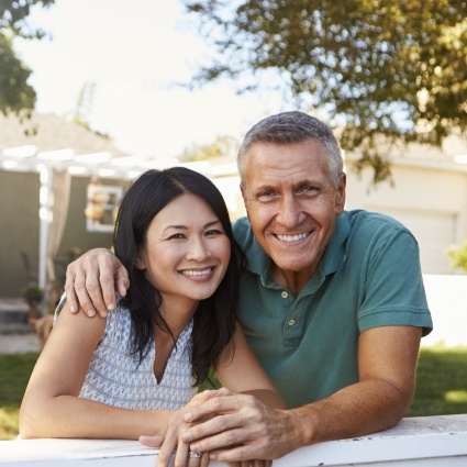 Man and woman smiling while lying on lawn