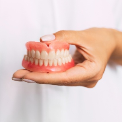 Close up of dentist holding full dentures