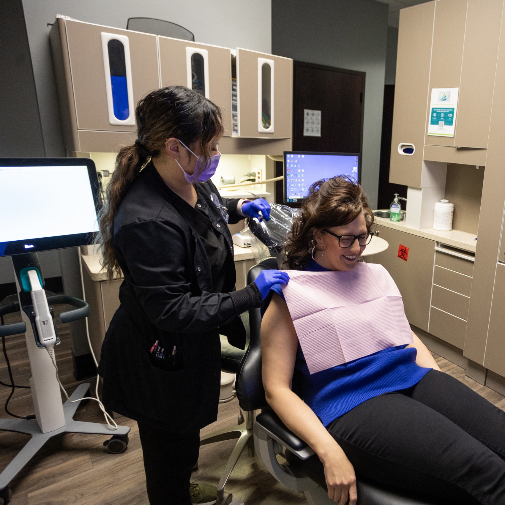 Dentist standing next to patient in dental chair