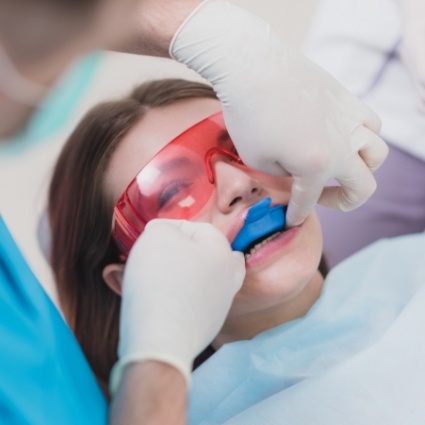 Little girl receiving fluoride treatment from dentist