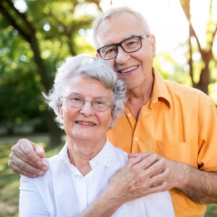 Senior man and woman smiling outside