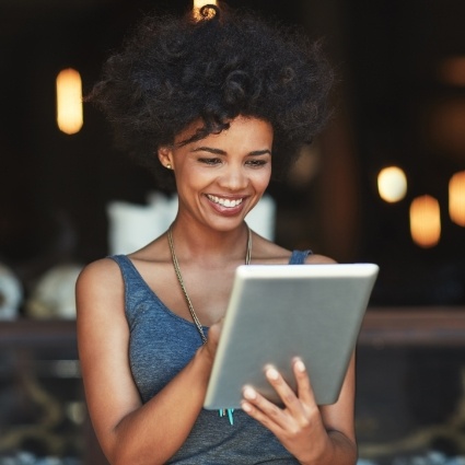 Woman smiling and looking at a tablet