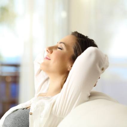 Woman in white sweater sitting back and relaxing