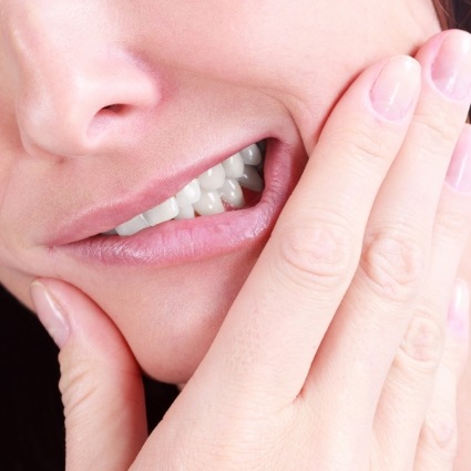 Close up of woman rubbing her jaw in pain