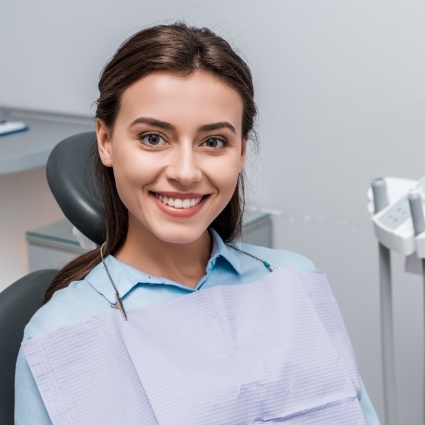 Woman sitting in dental chair and smiling