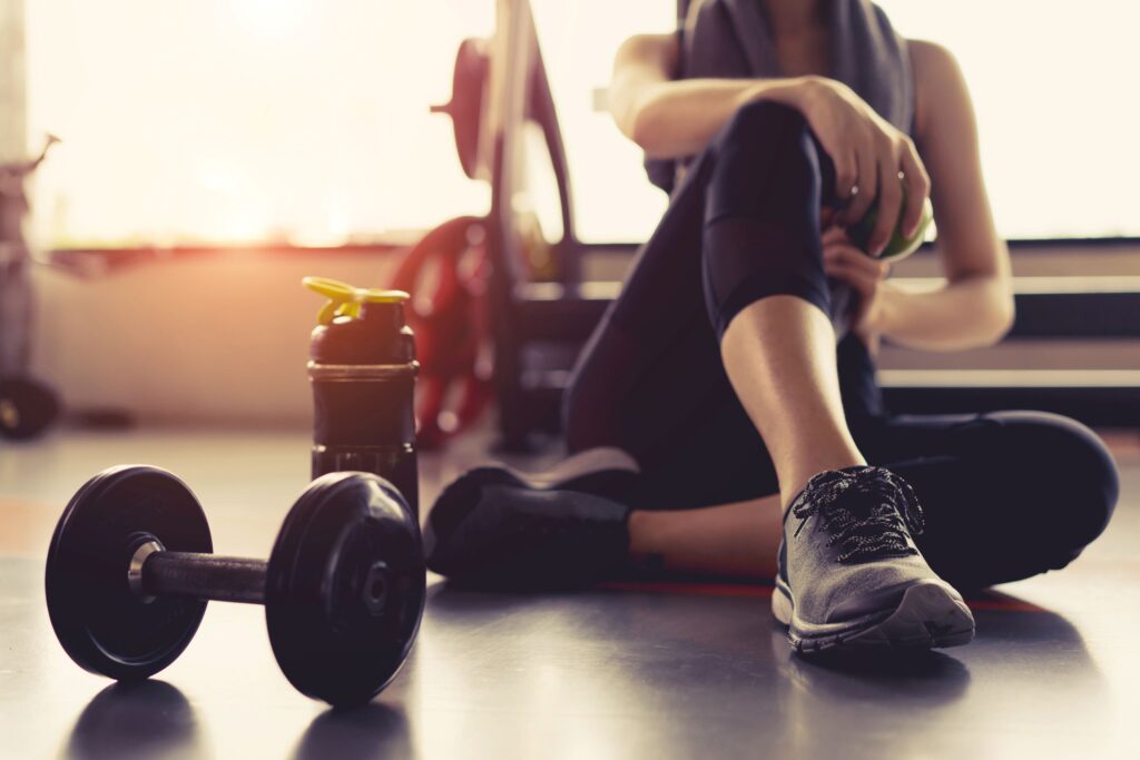 Woman taking a break with water bottle at the gym